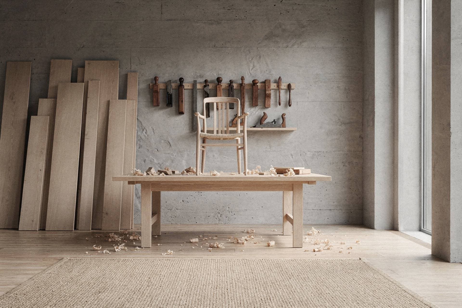 An oak chair frame on a workbench among oak boards, hand planes and wood shavings